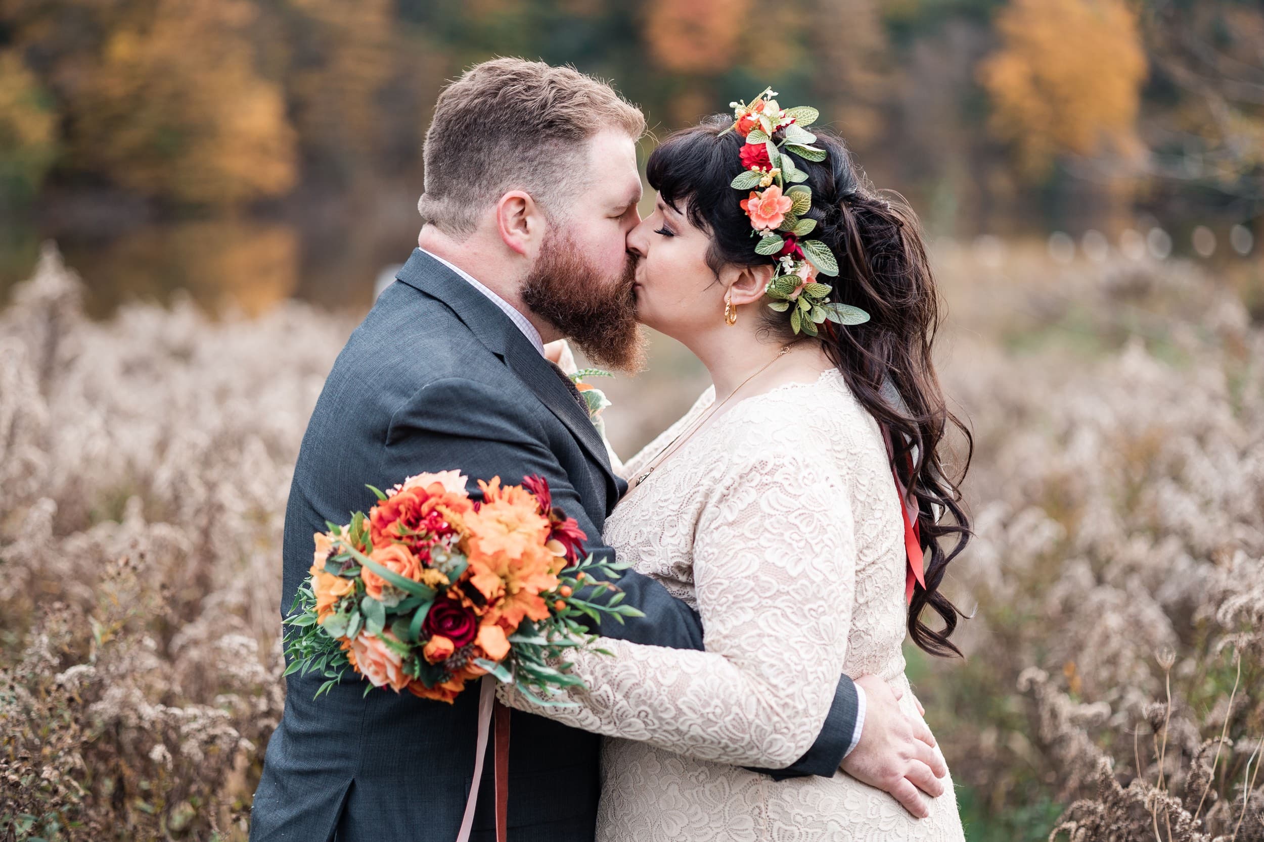 Wedding couple embracing in a field during golden hour at Christie Lake In Hamilton Ontario.
